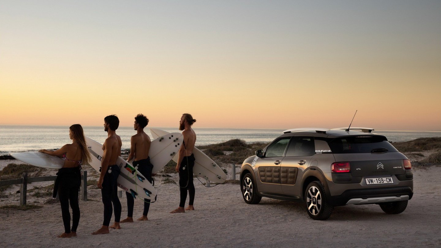 Wer siehts? Ein Auto-PR-Foto, auf dem die Frau mehr an hat als die Männer!