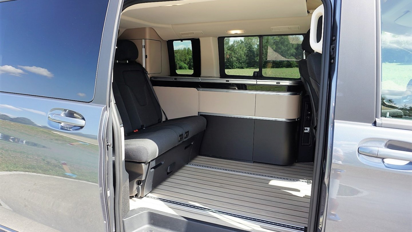 Neben der verschiebbaren Rücksitzbank ist die Küchenzeile mit Kühlschrank, Gasherd und Spüle.