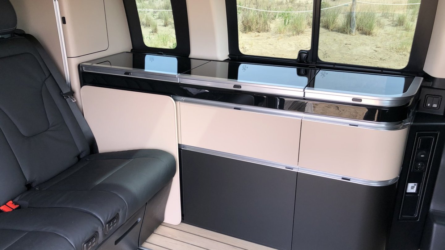 Die Küchenzeile mit Kühlschrank, Gasherd und Spüle.