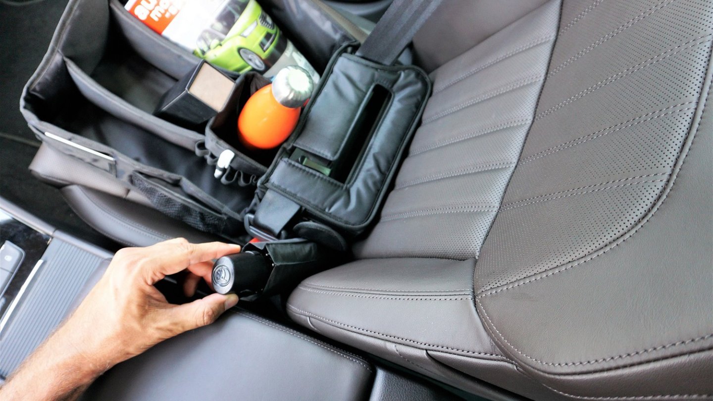 Der Schirm findet nicht in sein Fach - denn Mittelkonsole und Gurtschnalle sind im Weg.